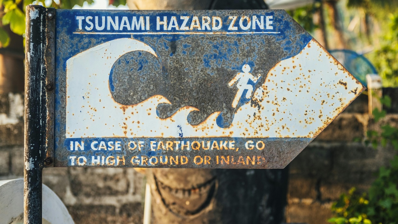 People practicing Drop, Cover, and Hold On and an emergency kit on a table