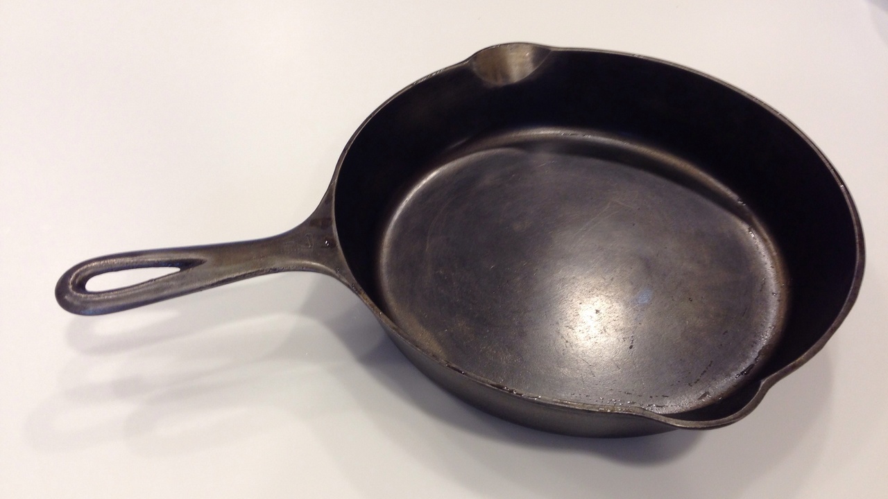 Cast iron skillet and steaming vegetables on stove