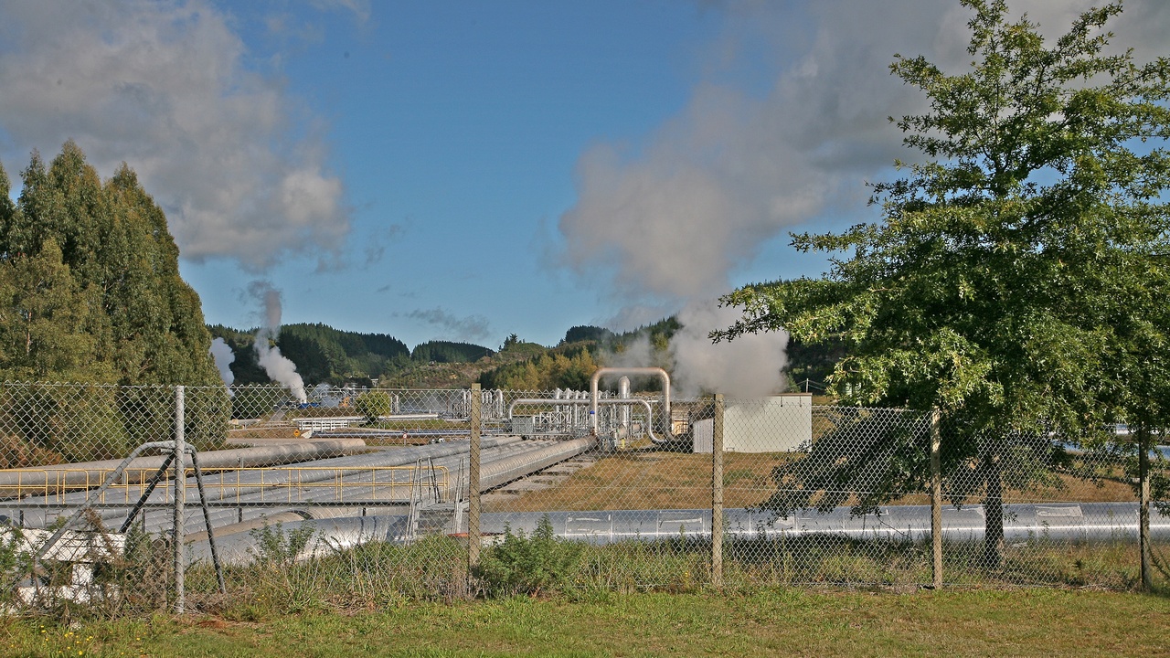 Geothermal power plant with steam vents near volcanic landscape