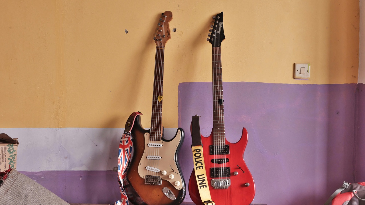 Electric guitar close-up and mixing console representing rock instrumentation and studio technology