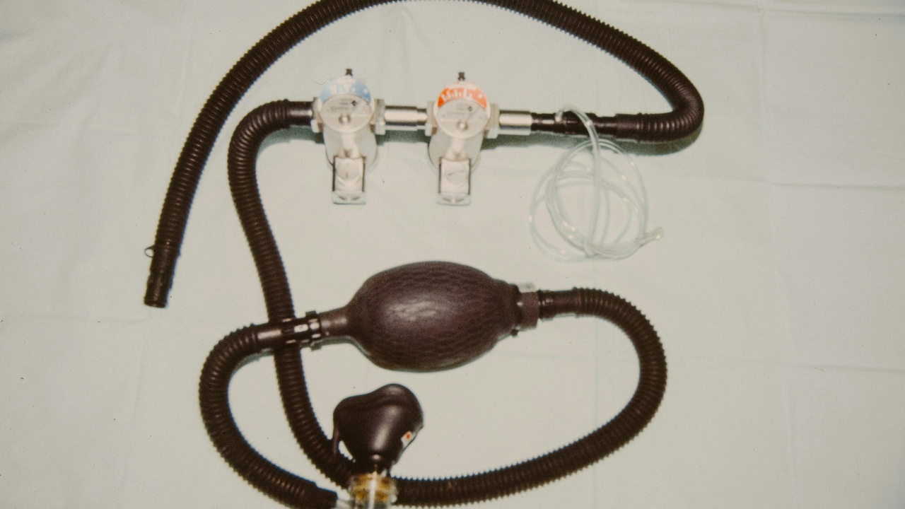Laparoscope and needle holders beside suction device on an OR table.