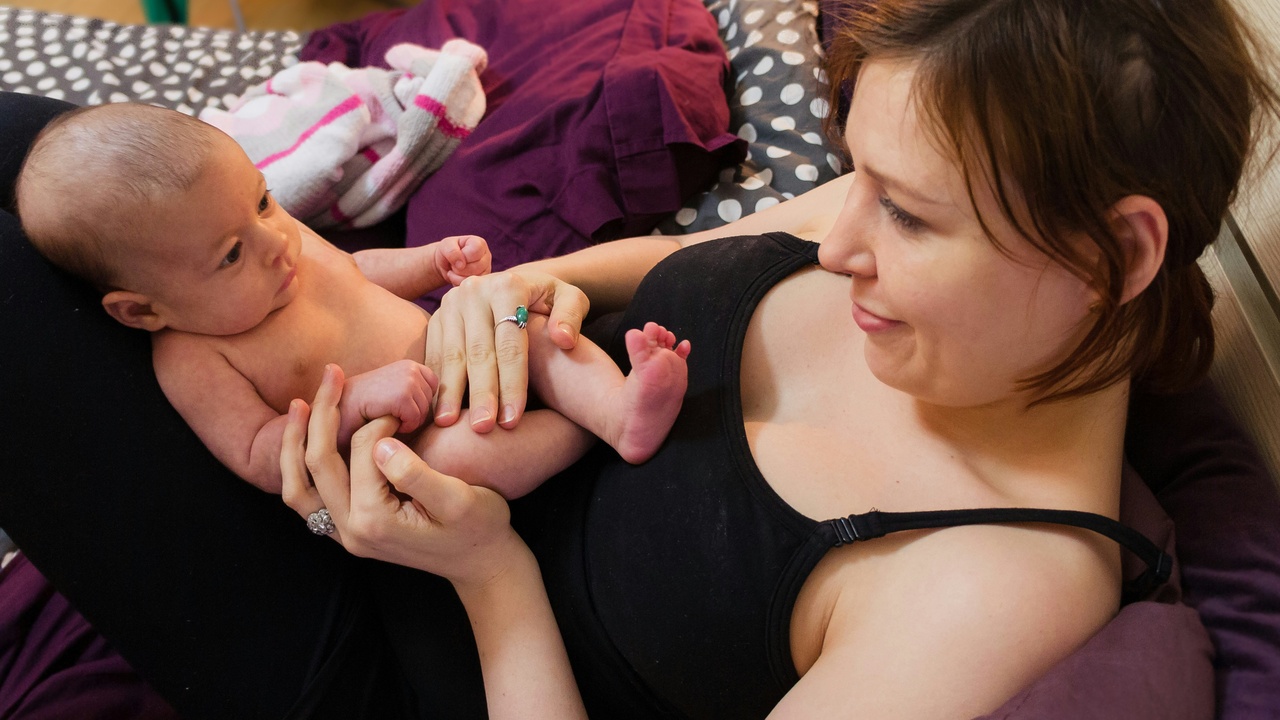 Parent using a breast pump at work, representing workplace support and economic implications of breastfeeding