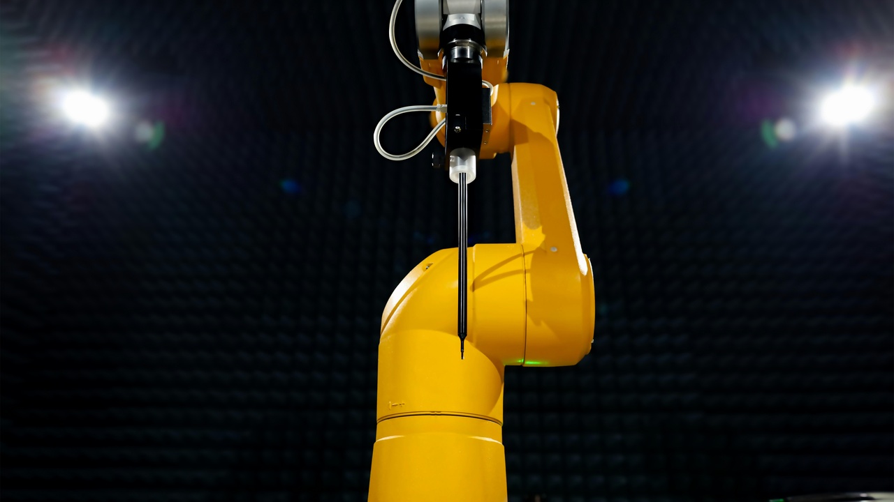 A service robot in a public space with safety barriers and warning signage.