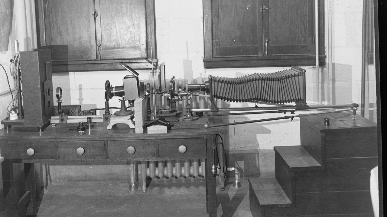 Micropipettes and centrifuge on a laboratory bench with a microplate reader