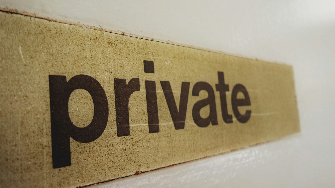 Person submitting saliva sample with a lock icon representing genetic data privacy.