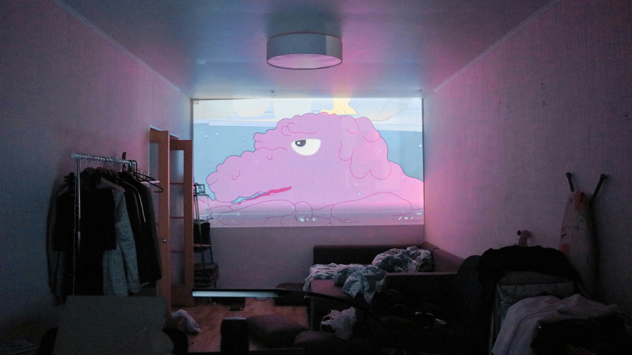 Living room projector installed on ceiling projecting onto a screen
