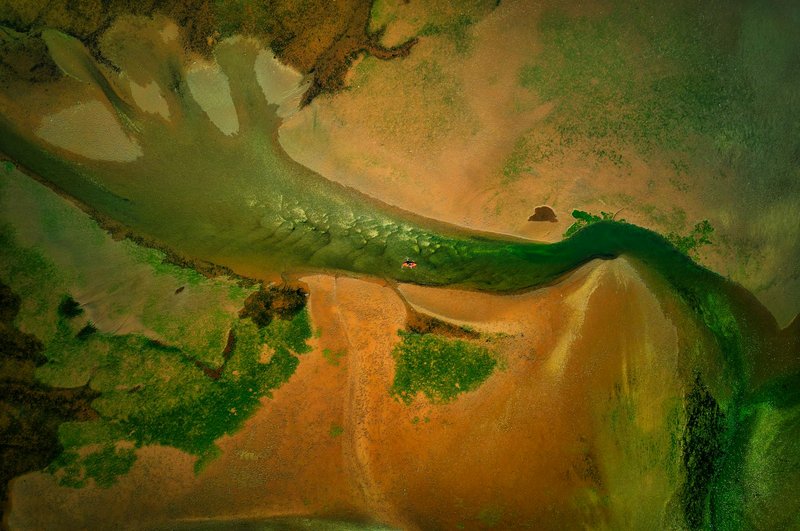 Drone shot of a kayaker navigating the vibrant estuary waters near Exmouth, UK.