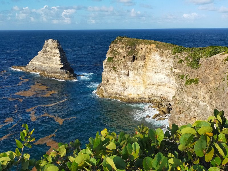 A breathtaking view of rugged cliffs and blue ocean under a sunny sky.