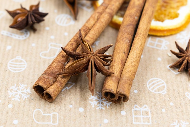 Macro shot of cinnamon sticks and star anise on decorative paper.