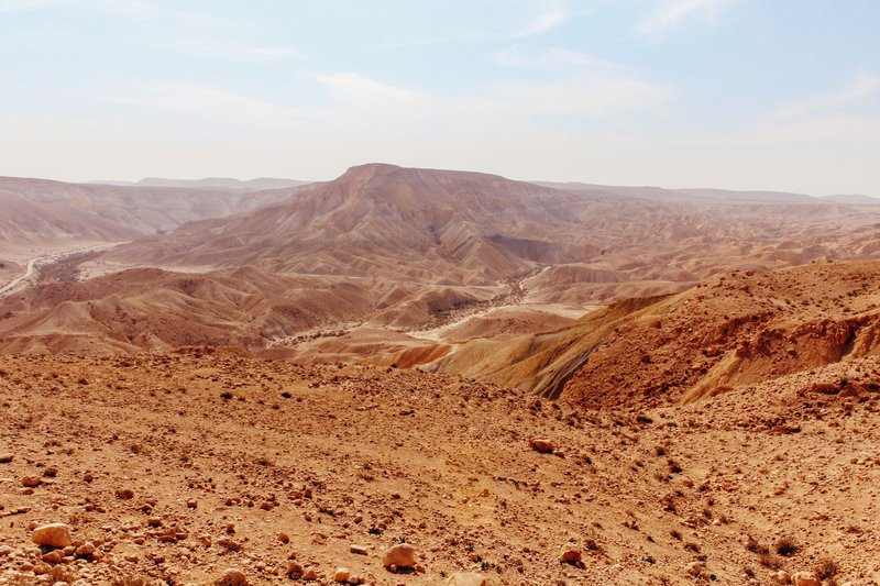 A vast and arid mountainous desert landscape under a clear blue sky.