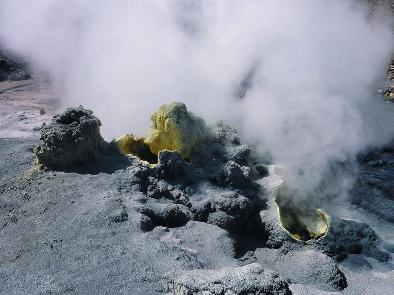 Dynamic geothermal vents emitting steam in Kamchatka's volcanic landscape, Russia.