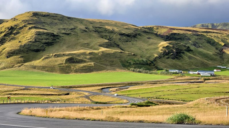 Beautiful view of winding road and rolling hills in Iceland's rural landscape.