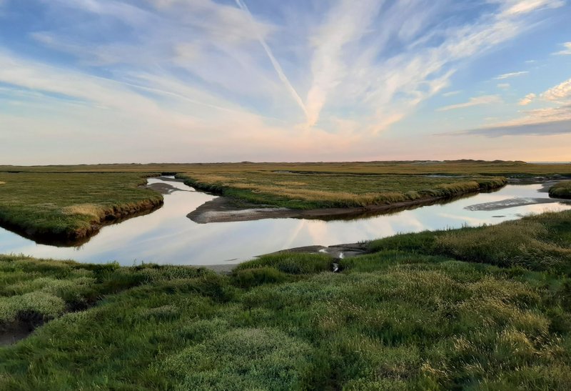 Beautiful salt marsh reflecting the sky during sunset at Sankt Peter-Ording, Germany.