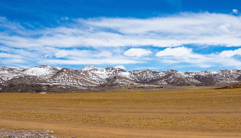 Beautiful snow-capped mountains under a clear blue sky in Ngari, Tibet.