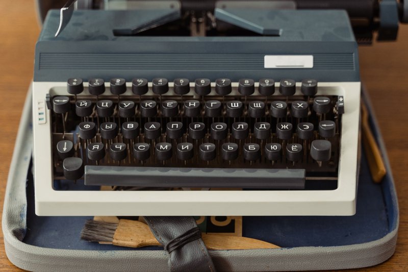 Close-up of a vintage typewriter with Cyrillic keys on a wooden table.