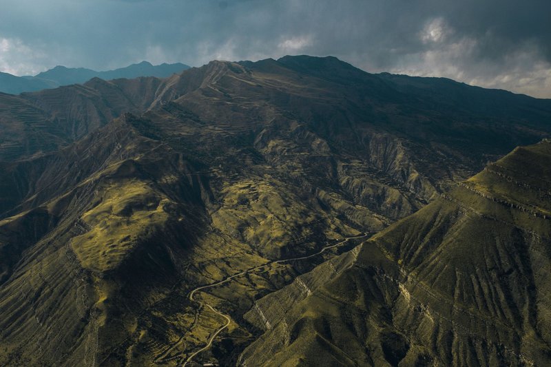 A stunning aerial view capturing rugged mountain landscapes under an overcast sky.
