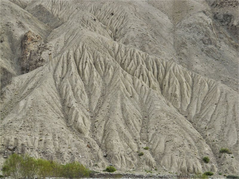 Dramatic erosion patterns on rocky terrain in Ladakh, India showing natural sculpting by wind and water.