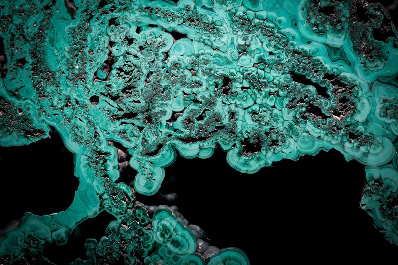 Abstract image showing intricate malachite patterns and textures in vivid green.