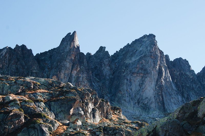 Striking rocky mountain peaks under a clear blue sky, a perfect scene for adventure and travel enthusiasts.