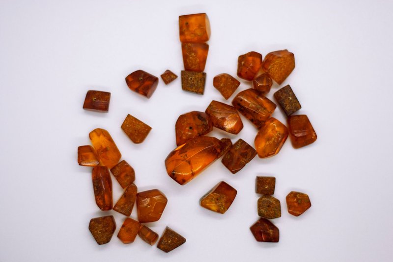 A collection of natural amber gemstones displayed on a white surface.