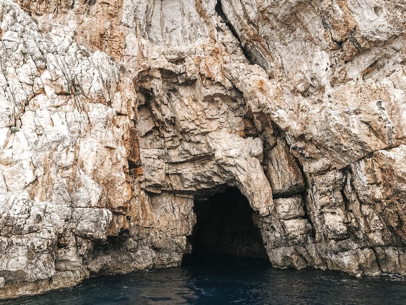 Discover the breathtaking entrance of a sea cave in Gaios, Greece, carved into limestone.