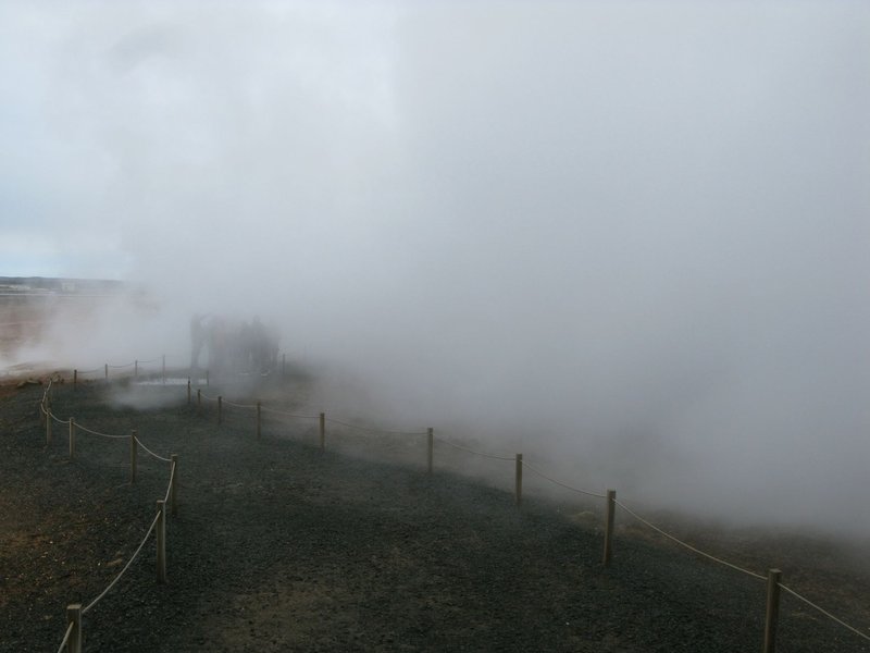 Geothermal landscape with dense steam and mist creating a mysterious atmosphere.