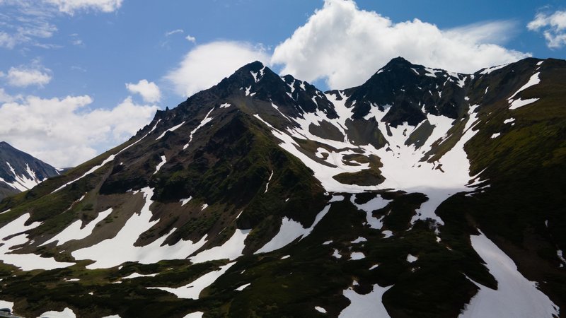 Breathtaking aerial view capturing the snow-covered peaks of Kamchatka under a vibrant blue sky.