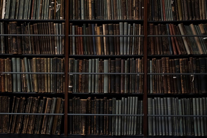 A close-up of vintage books on library shelves in London, showcasing an abundance of literary history.