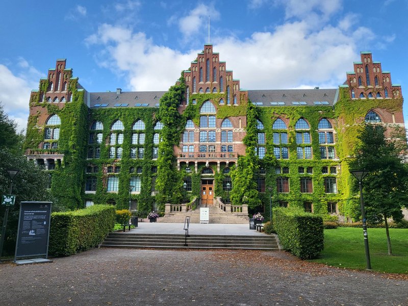 Front view of a historic ivy-covered university building under a clear sky.