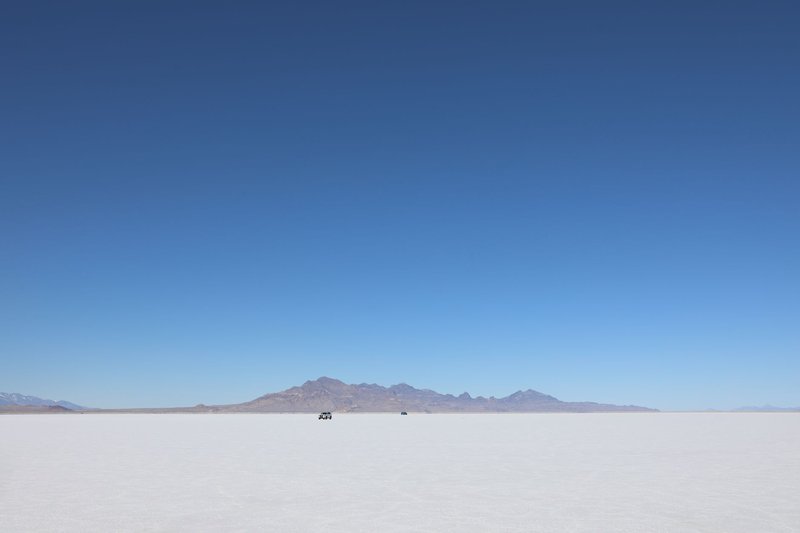 Expansive Bonneville Salt Flats with distant mountains under a clear blue sky.