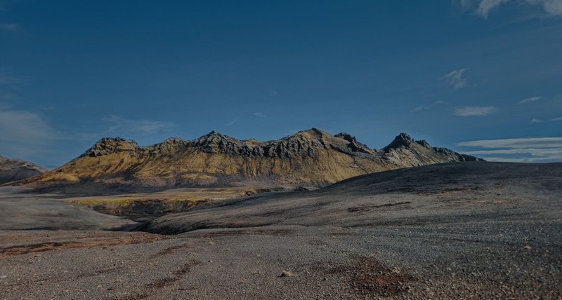 Expansive volcanic landscape in Þingeyjarsveit, Iceland, under clear blue sky.