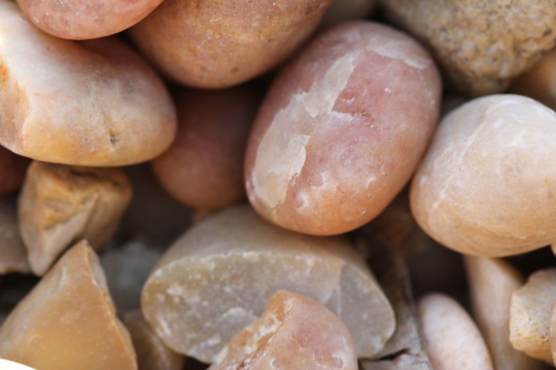 Macro photograph of smooth, colorful pebbles, showcasing texture and pattern.