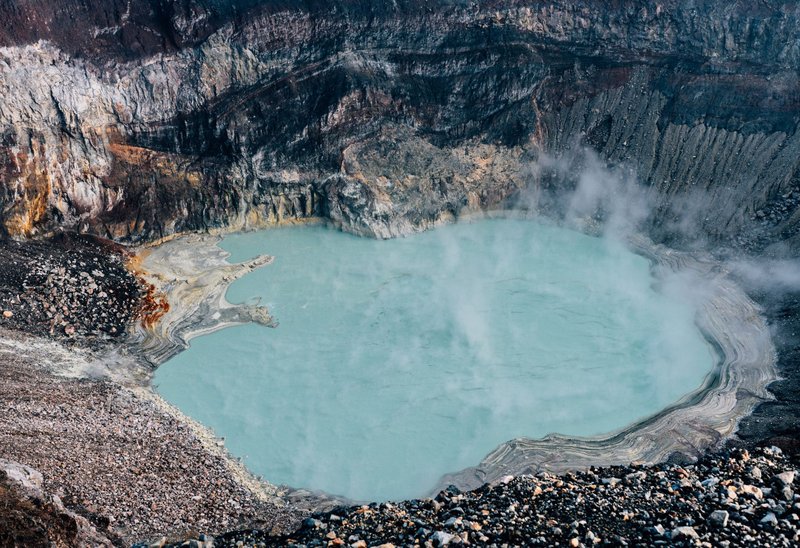 A breathtaking aerial view of a turquoise lake nestled within a volcano crater in El Salvador.