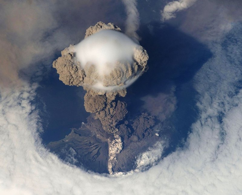 Stunning bird's eye view of a volcanic eruption with massive ash cloud and smoke plumes.
