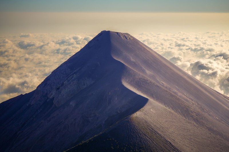 Breathtaking aerial view of Acatenango Volcano peak above the clouds in Guatemala.