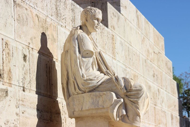 Seated stone sculpture from ancient Greece in Athens, captured in natural light.
