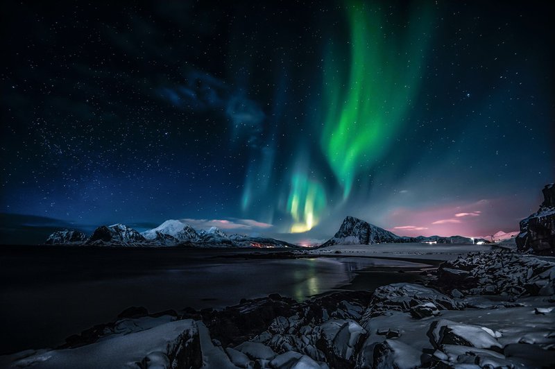 Breathtaking view of the Northern Lights illuminating the snowy landscape of Nordland, Norway.