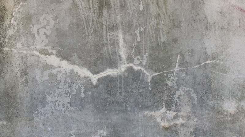 High-resolution image of a weathered and cracked concrete wall, perfect for texture background uses.