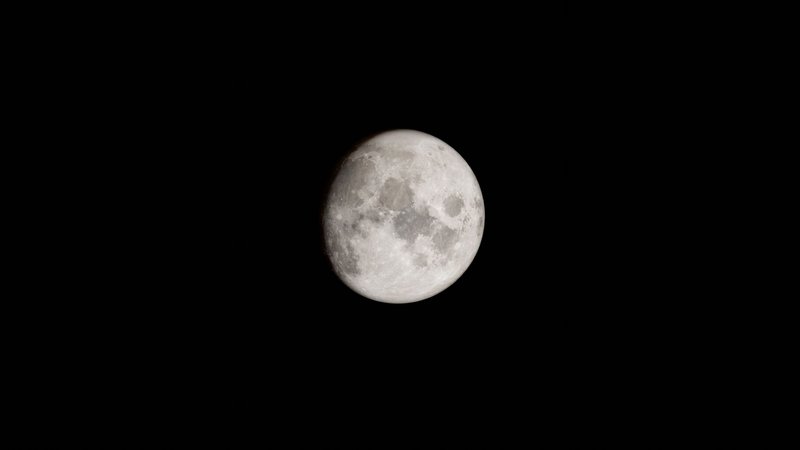 A detailed capture of the full moon set against a stark black sky, ideal for astronomy enthusiasts.