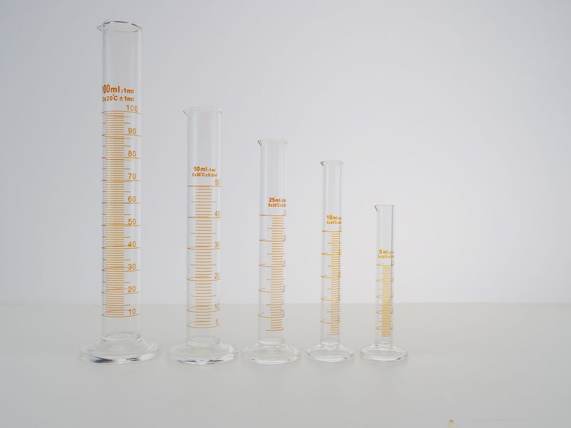 A lineup of laboratory graduated cylinders in different sizes, perfect for science experiments.