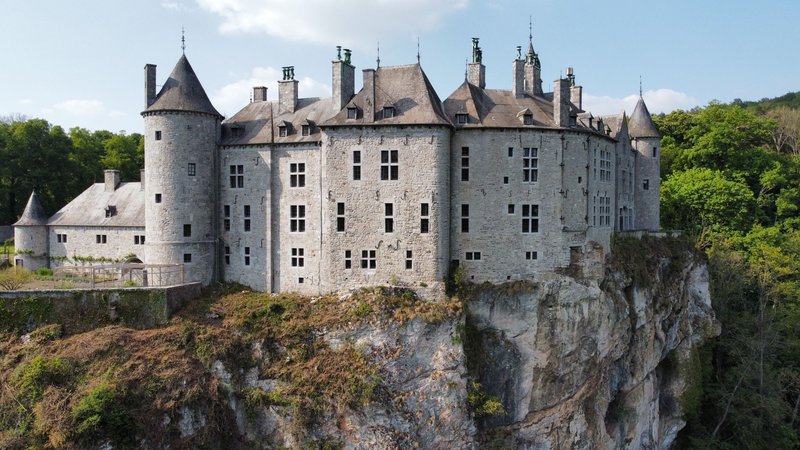 A stunning view of the historic Walzin Castle perched on a cliff in Belgium, showcasing medieval architecture.
