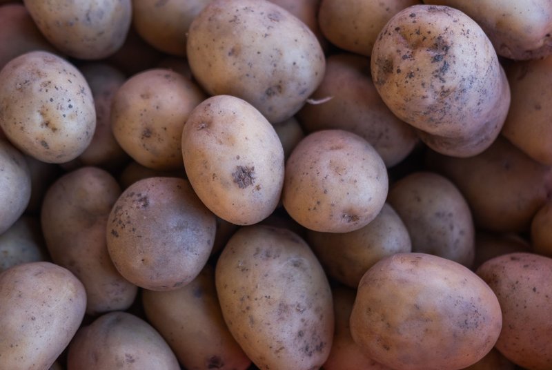 A vibrant close-up of fresh potatoes displayed at a market in İzmir, Türkiye, showcasing their earthy texture.