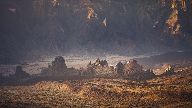Breathtaking view of volcanic rock formations under a golden sunset in Tenerife, Spain.