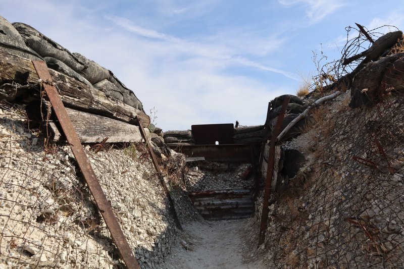 Explore a preserved World War I trench in Massiges, France, during a sunny day.