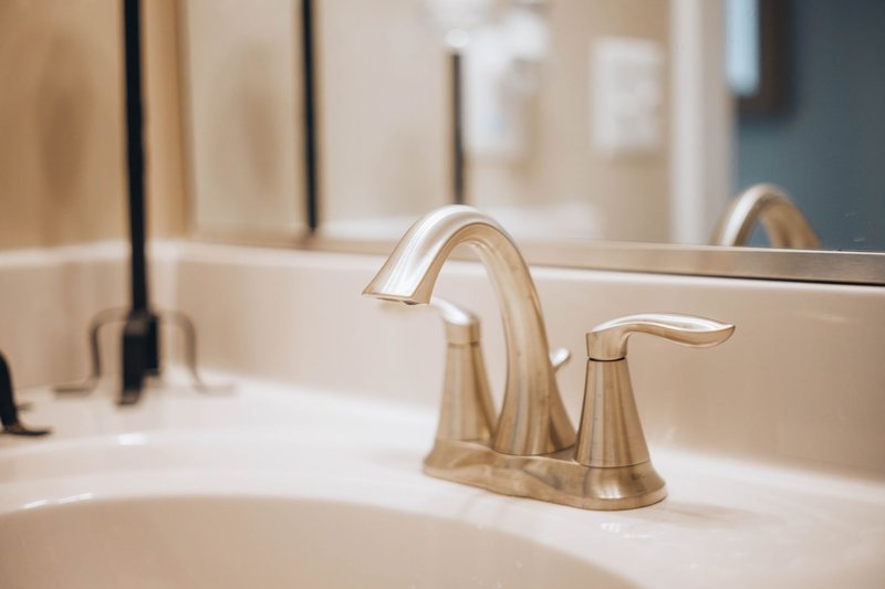Close-up of a sleek modern bathroom faucet reflecting elegance and luxury.