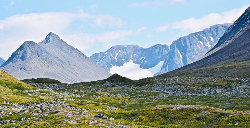 Expansive view of a glacier nestled within a majestic alpine mountain range.