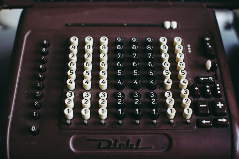 Close-up of a vintage Diehl mechanical calculator with visible numeric keys and brown casing.