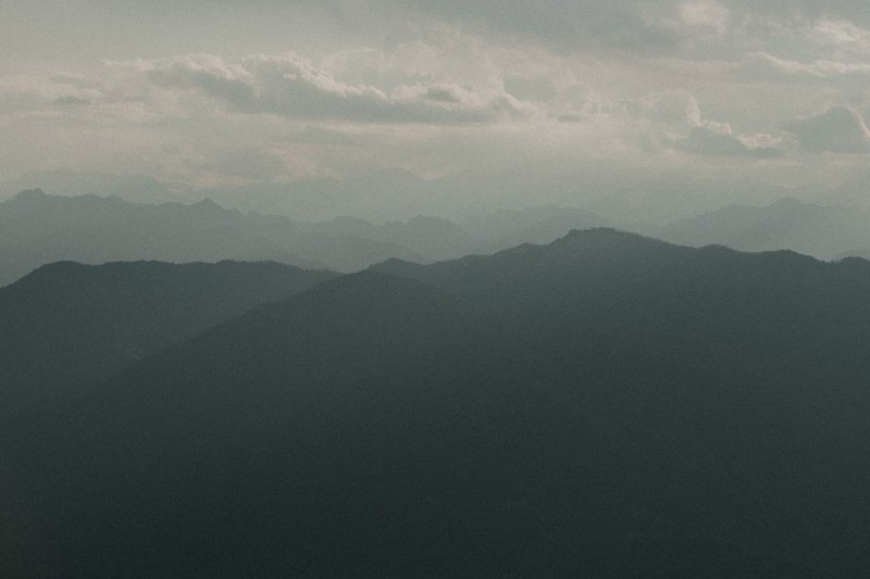 Serene view of misty mountain ranges at dusk in Mottarone, Italy.