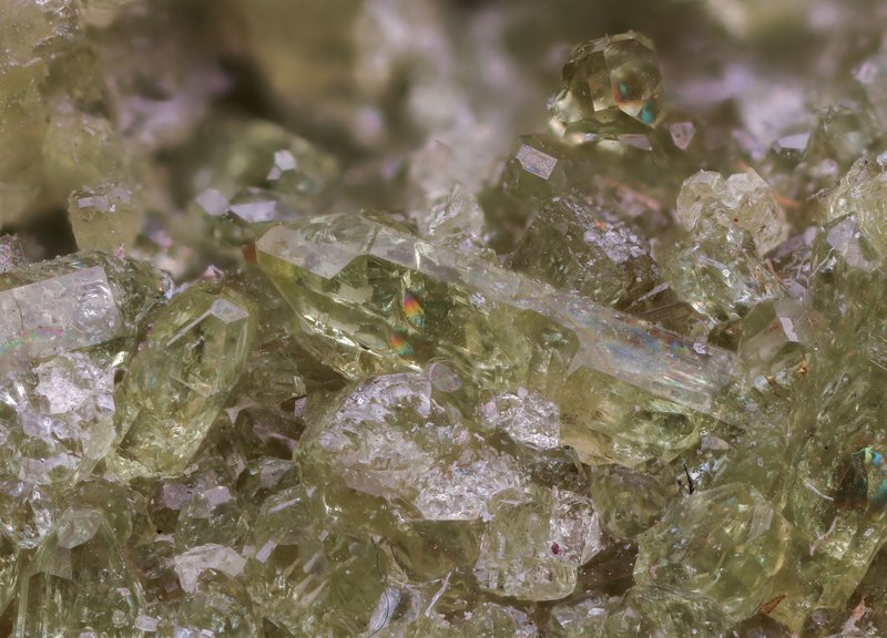 Detailed close-up of translucent green crystals and gemstones with delicate textures and shimmering effects.