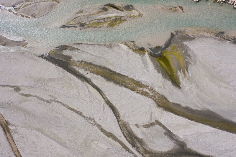 Captivating aerial view of a tranquil river flowing through unique sand patterns.